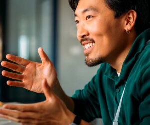 A asian man with a green t-shirt gesticulating with his hands -Agent model