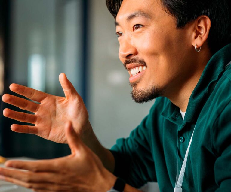 A asian man with a green t-shirt gesticulating with his hands -Agent model